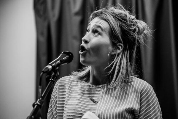 Jess Green performing poetry at a microphone