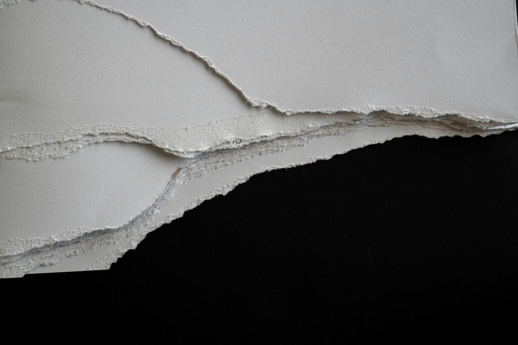 Layered paper textures, light catching their torn edges