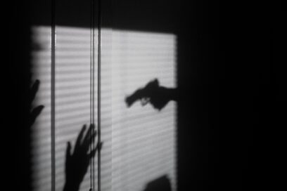 Silhouette of a gun being aimed at a person.