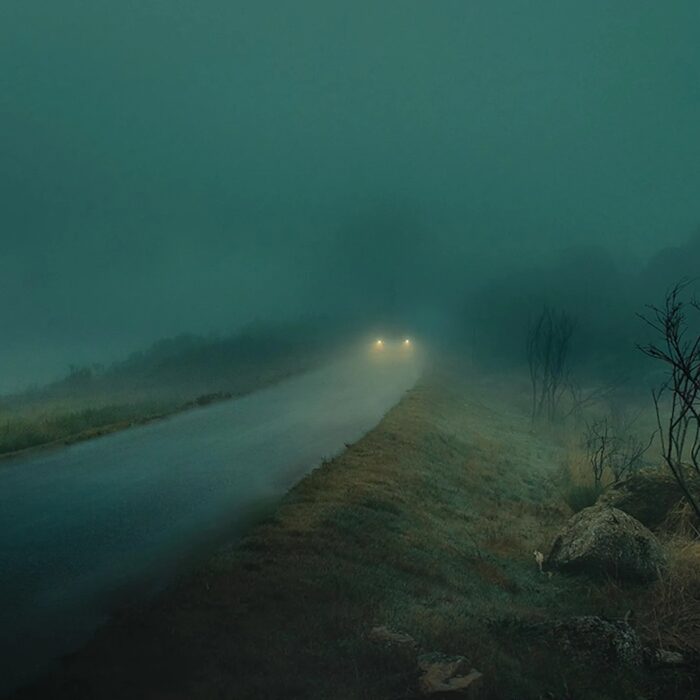Hazy Middle Eastern coastline at dusk with distant ships on the horizon.