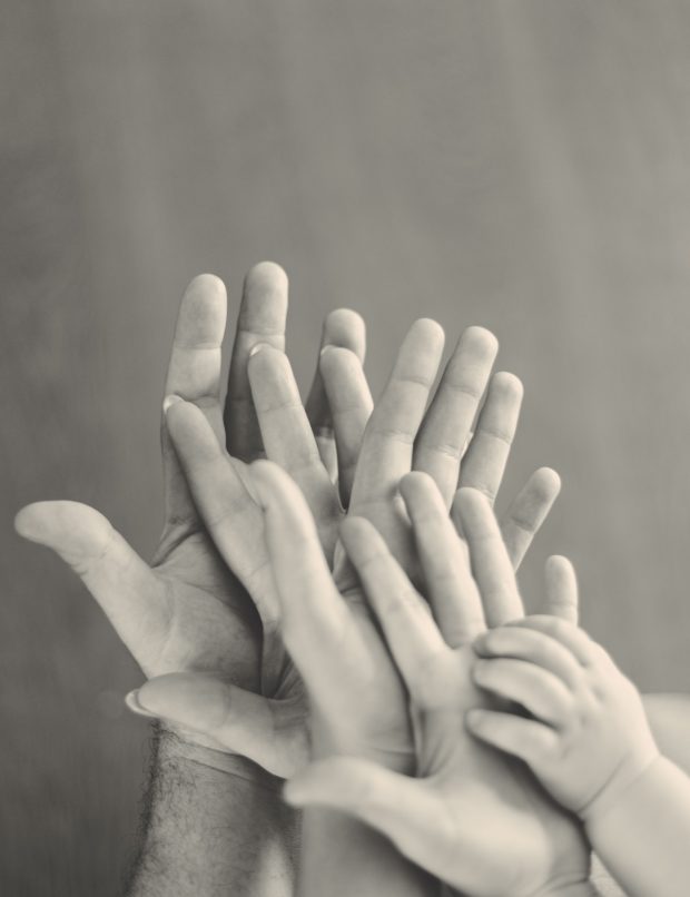 Grayscale photo of a family's hands