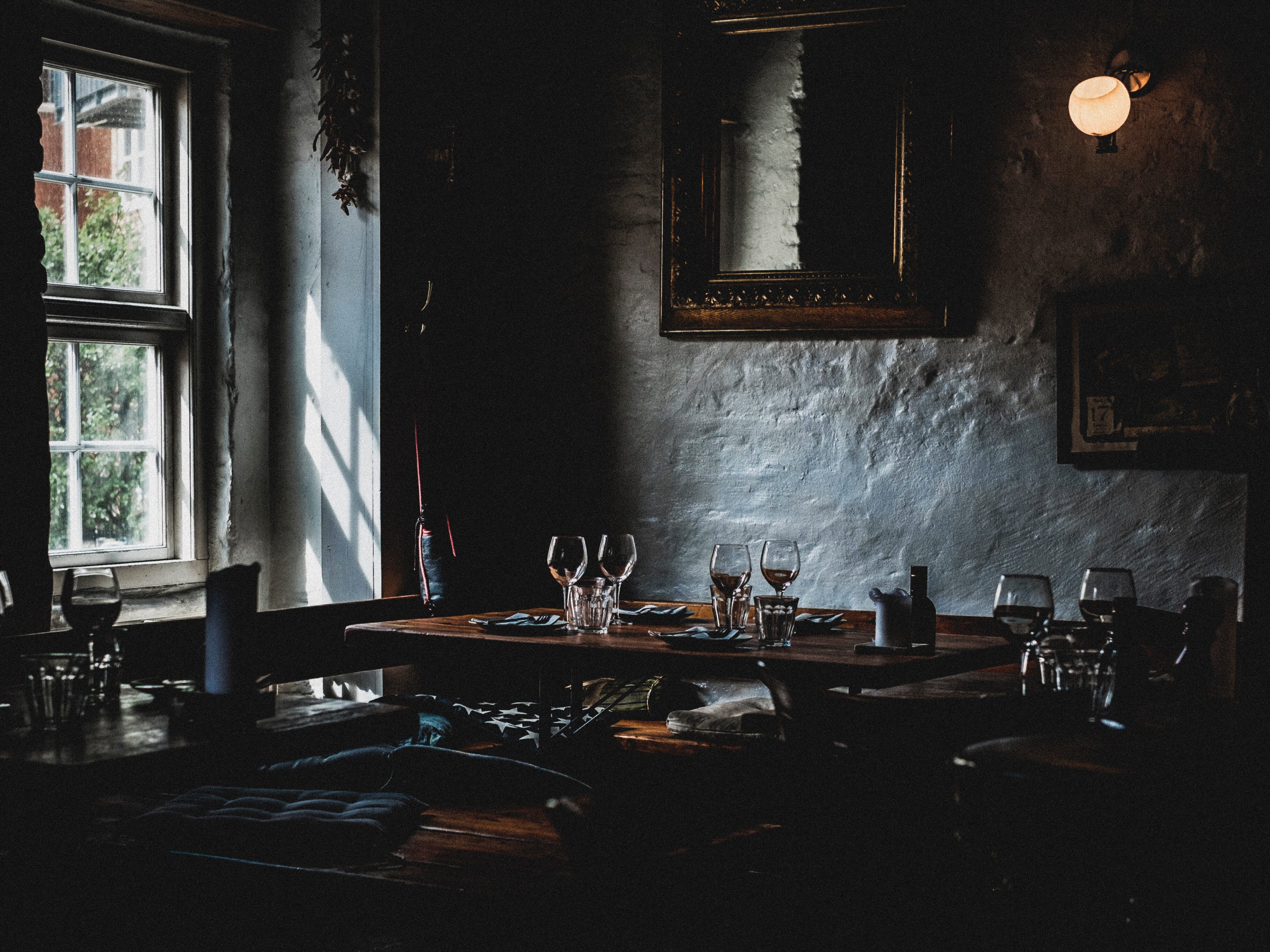 Image of a dimly lit pub with empty tables, capturing the quiet and somewhat eerie atmosphere of an afternoon between lunch and dinner service. 