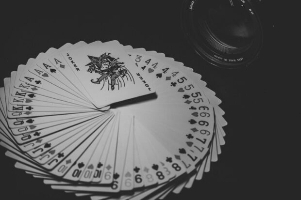 Image of a pack of cards spread out on a table, with the joker at the top, as if preparing for a magic trick.