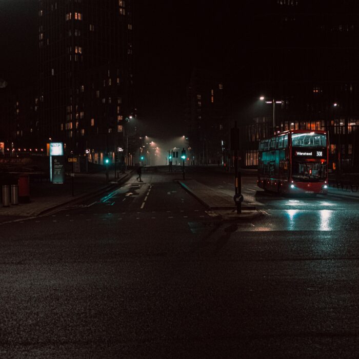 Passengers sit inside a city bus in winter daylight, separated by glass, reflection, and private thought.