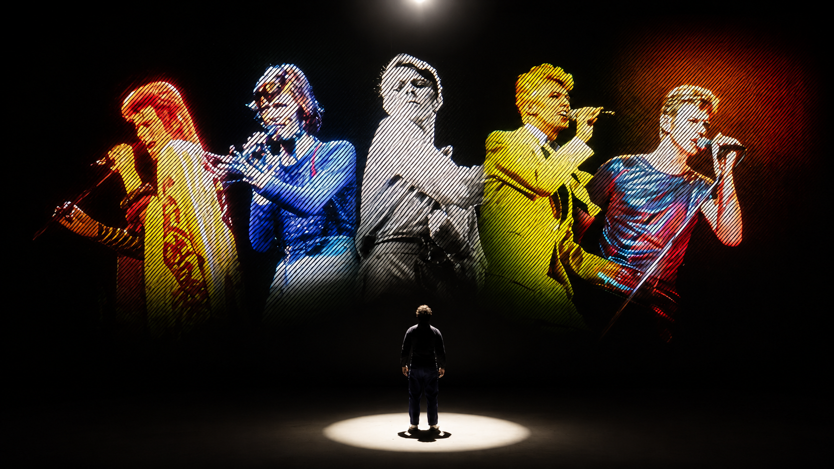 Visitors inside Lightroom surrounded by projected David Bowie footage on the walls and floor