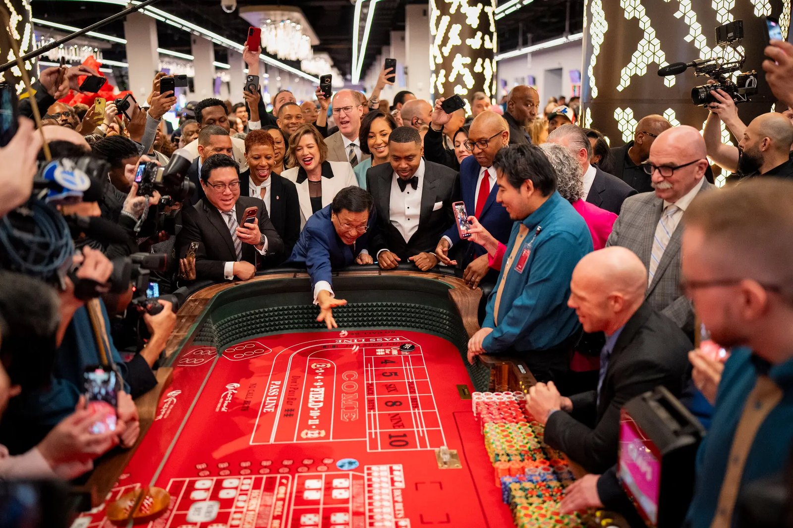 Crowd gathered around a casino table at the Resorts World opening in Queens