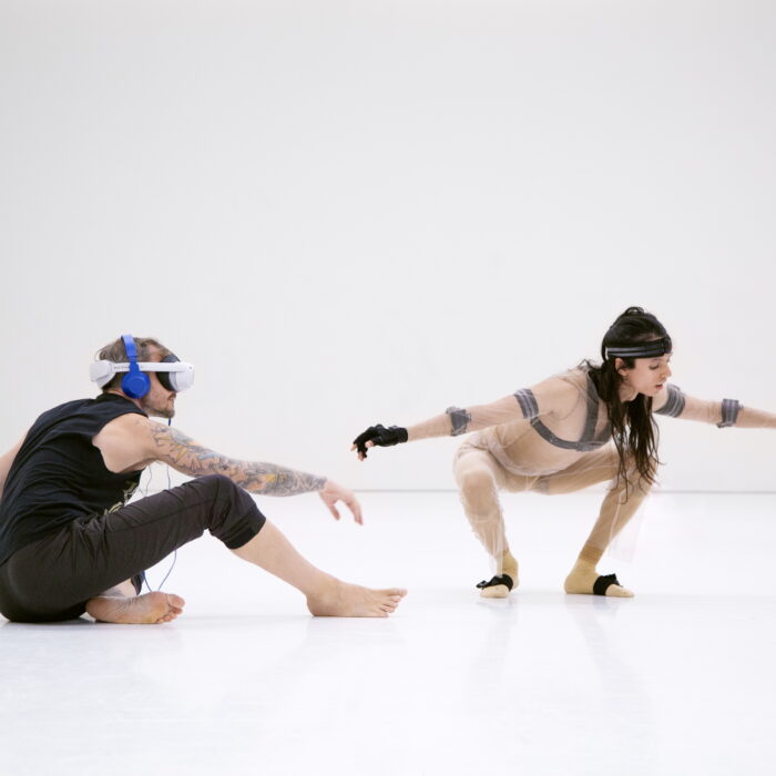 Audience participants and dancer inside Hinterlands by Rebecca Evans and Pell Ensemble, with a digital creature in a mixed-reality performance space.