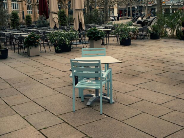 A quiet town green table and chairs in late summer light.