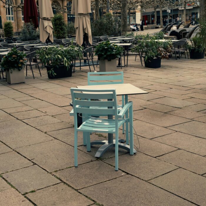 A quiet town green table and chairs in late summer light.